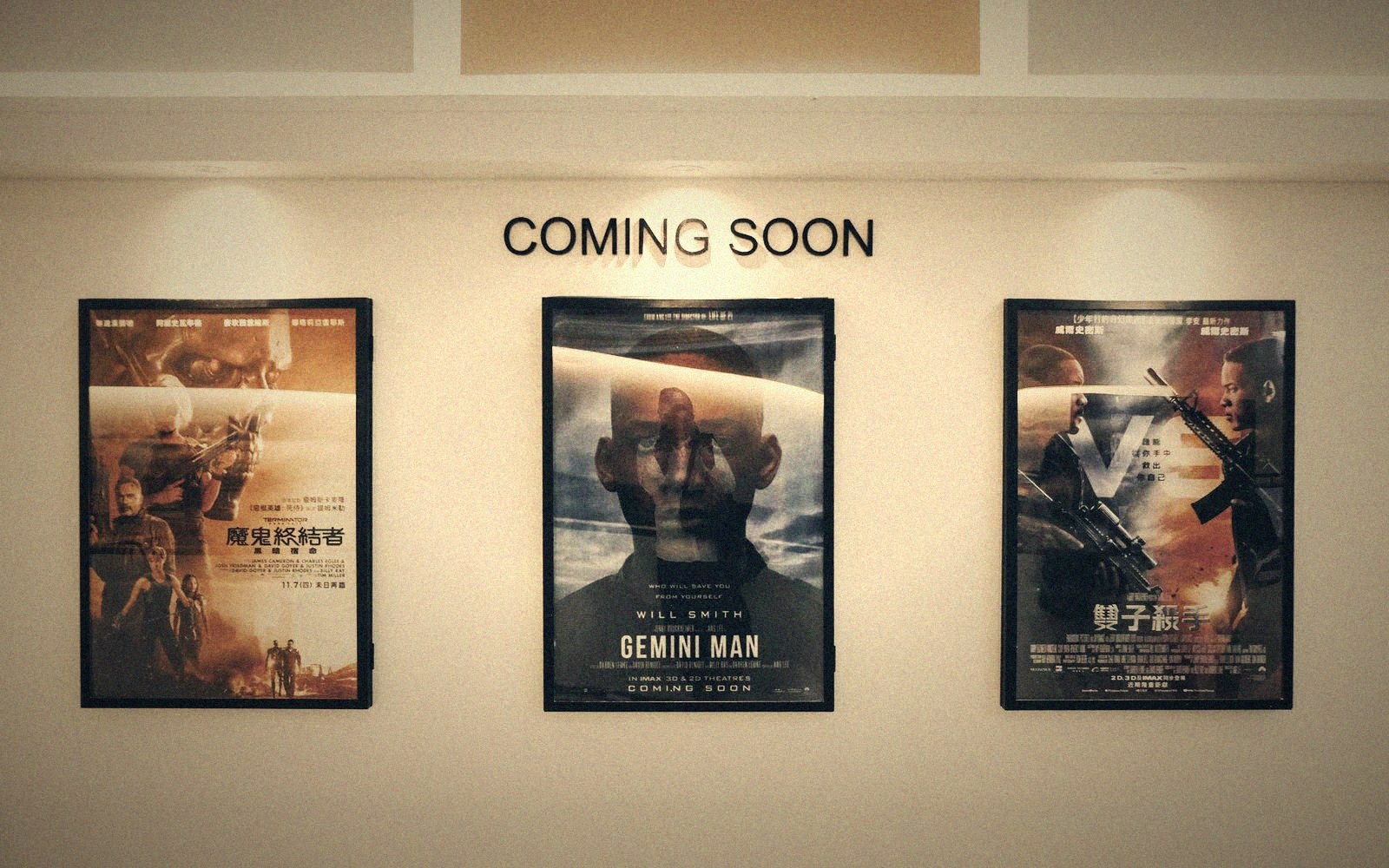 Framed movie posters including Gemini Man displayed under a coming soon sign in a cinema lobby