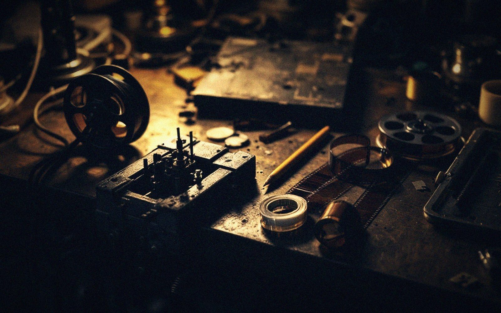 Film reels, splicing tape and cut strips of celluloid scattered across a workbench